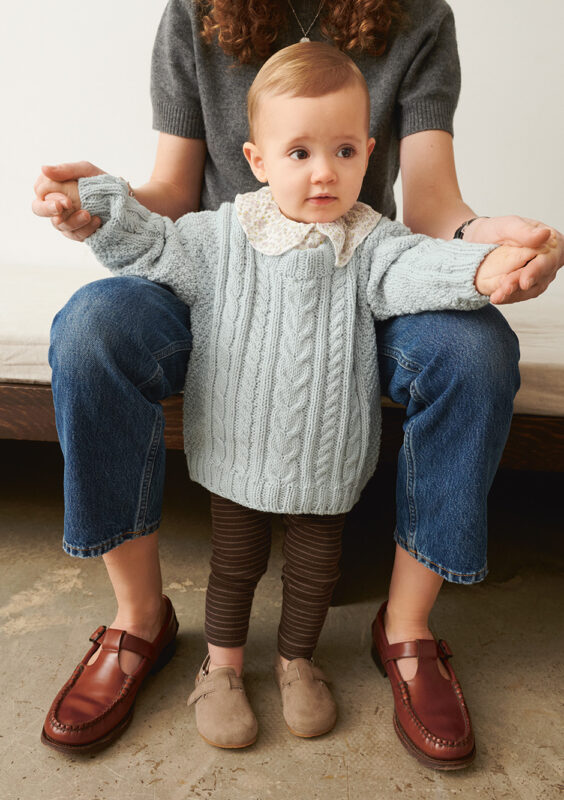 Barn som bär ljusblå Caspian Sweater Baby stickad I Sandnes Duo Arctic Ice 5811 i mönster för barn från Sandnes Garn.