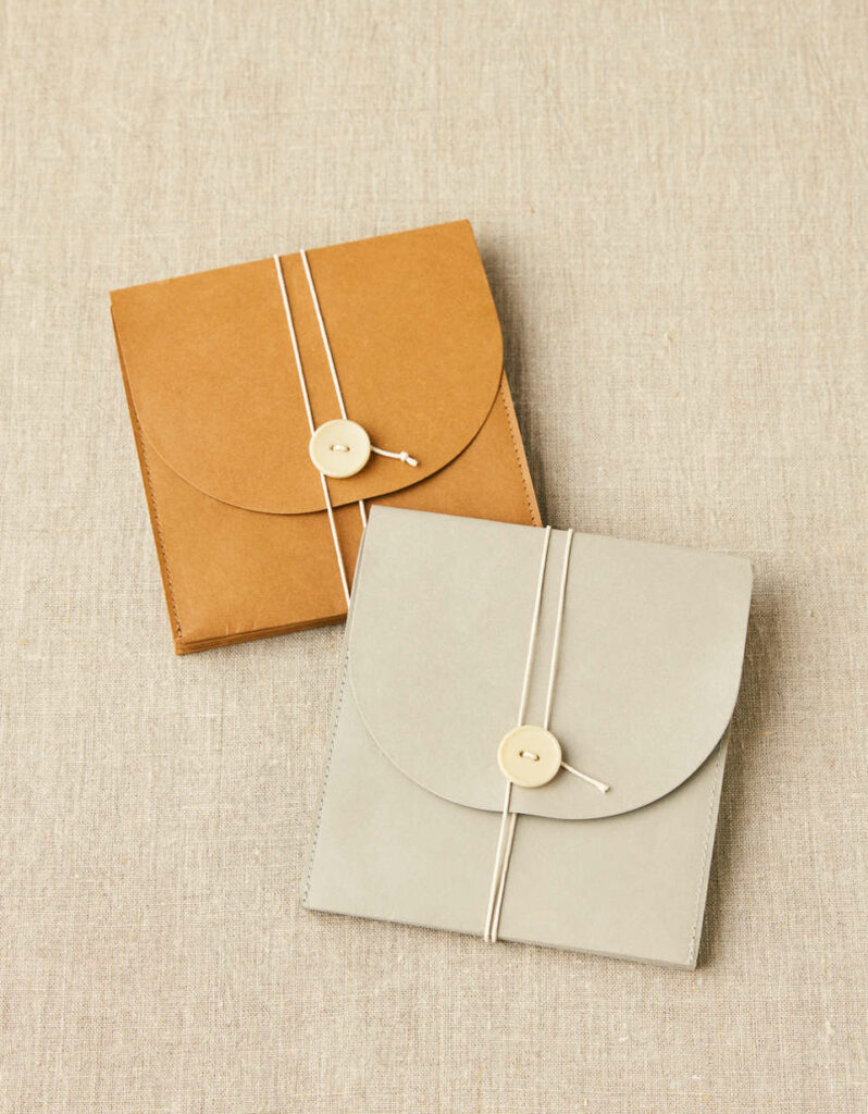 En brun och grå project wallet från Cocoknits som används för att förvara stickor och tillbehör.