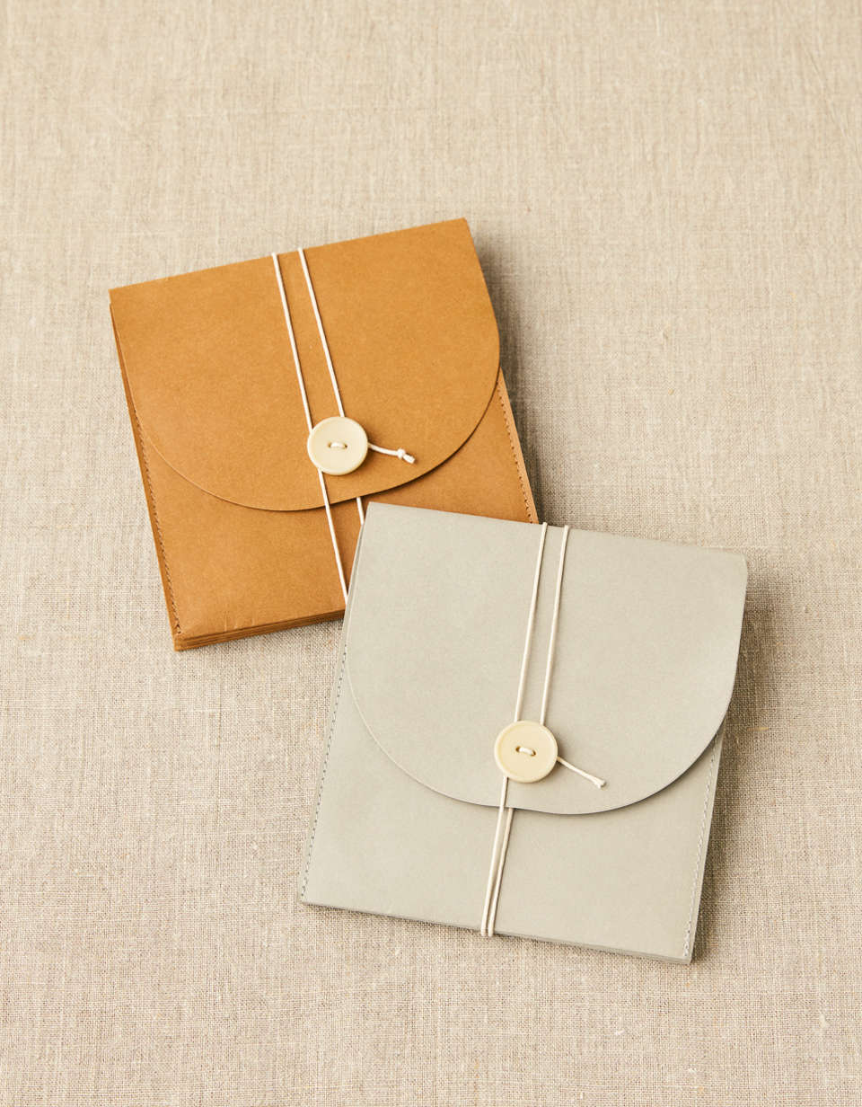 En brun och grå project wallet från Cocoknits som används för att förvara stickor och tillbehör.