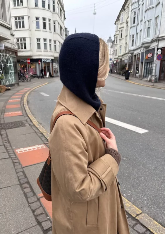 En kvinna som har på sig en mörkblå Barbara Balaclava stickad i Cashmere Classic från Cardiff i färgen Cosmo 647 i mönster från PetiteKnit.