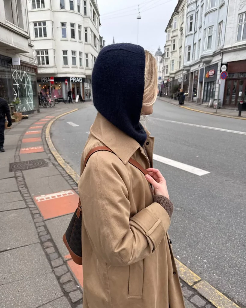 En kvinna som har på sig en mörkblå Barbara Balaclava stickad i Cashmere Classic från Cardiff i färgen Cosmo 647 i mönster från PetiteKnit.