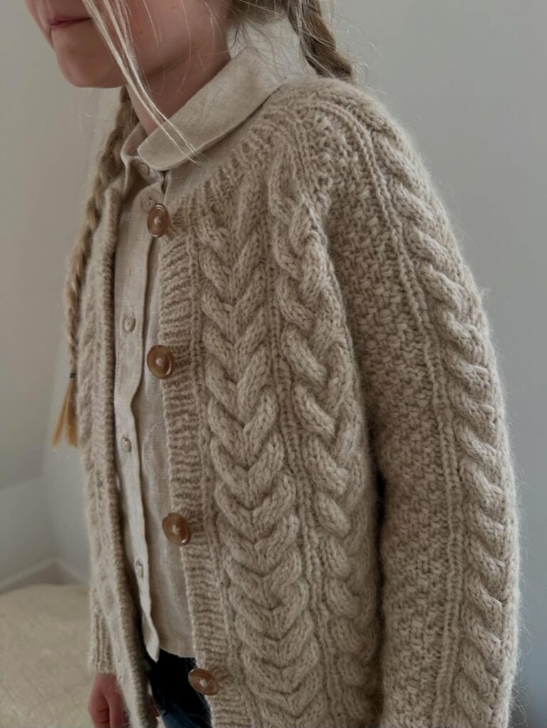 Flicka med flätor som bär Siri Cardigan från Le Knit