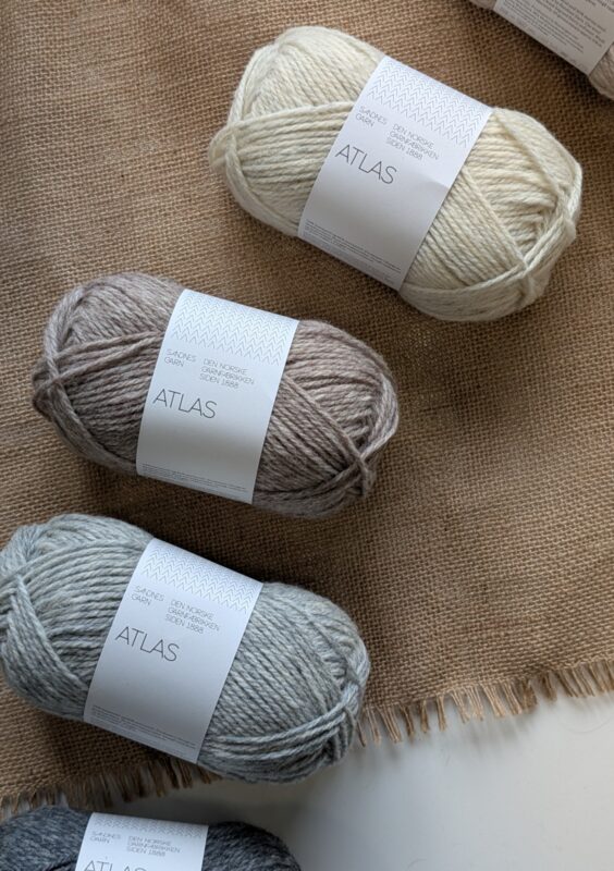 Garnet Atlas från Sandnes Garn som ligger på ett bord med brun duk under.